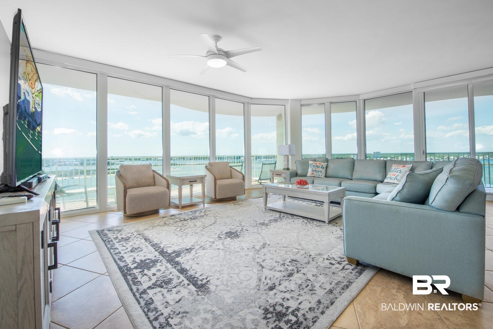 Image 2: Living room featuring a wall of windows and ceiling fan