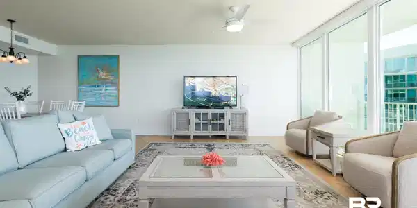 Image 4: Living area featuring a chandelier, floor to ceiling windows, and ceiling fan