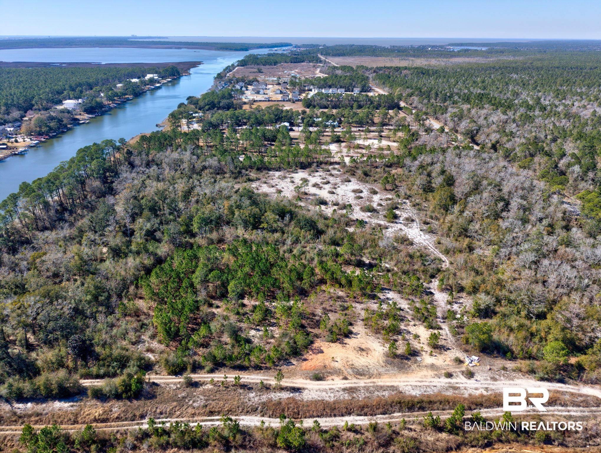 Image 4: Aerial view of property and surrounding area with a forest and a nearby body of water