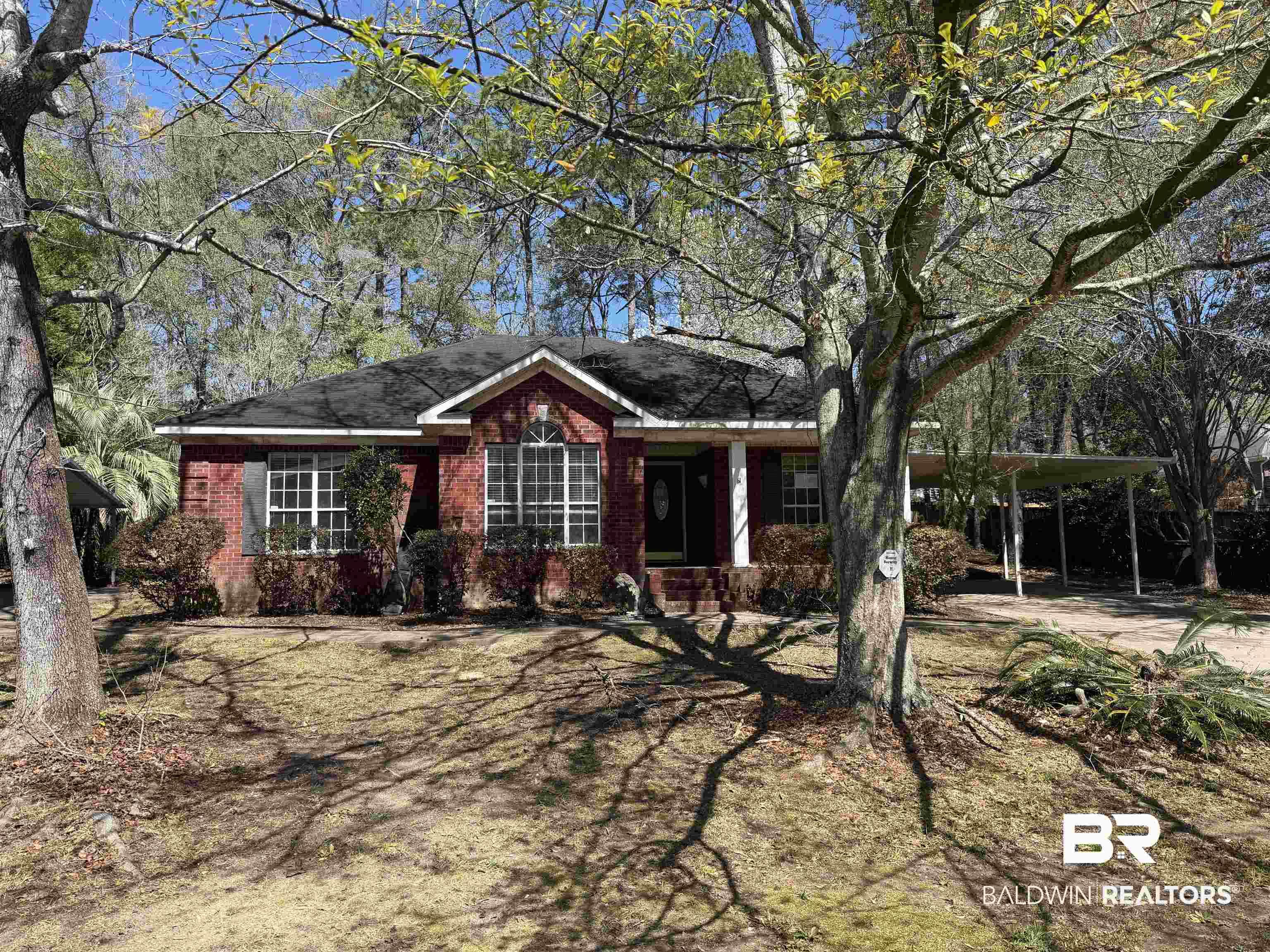 Image 2: Ranch-style home featuring a carport, brick siding, and covered porch