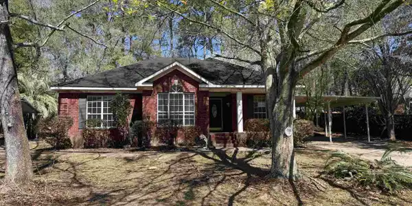 Image 2: Ranch-style home featuring a carport, brick siding, and covered porch