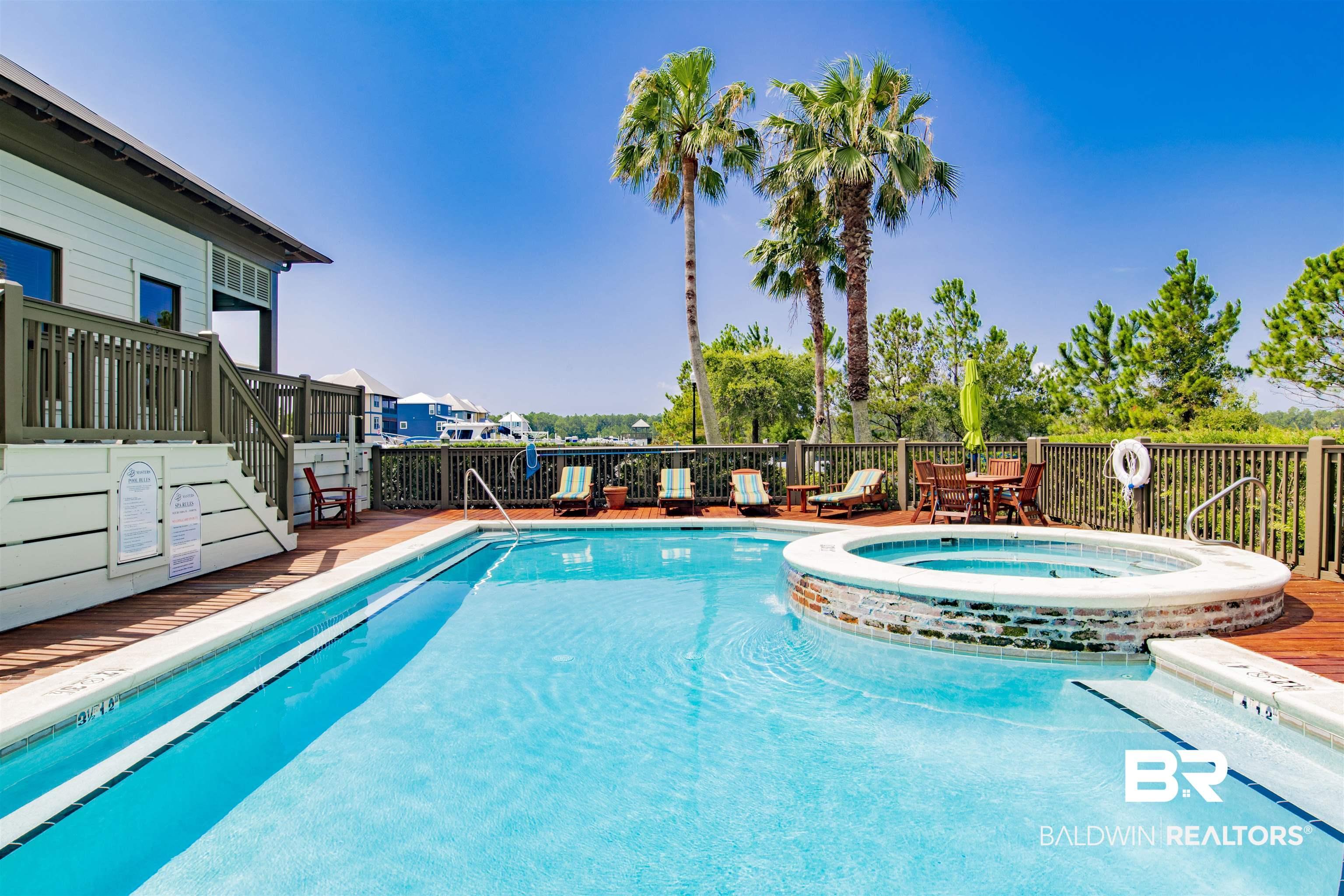 Image 4: Expansive outdoor pool area featuring a rectangular swimming pool, integrated circular spa with brick-finish surround, and a surrounding wood deck