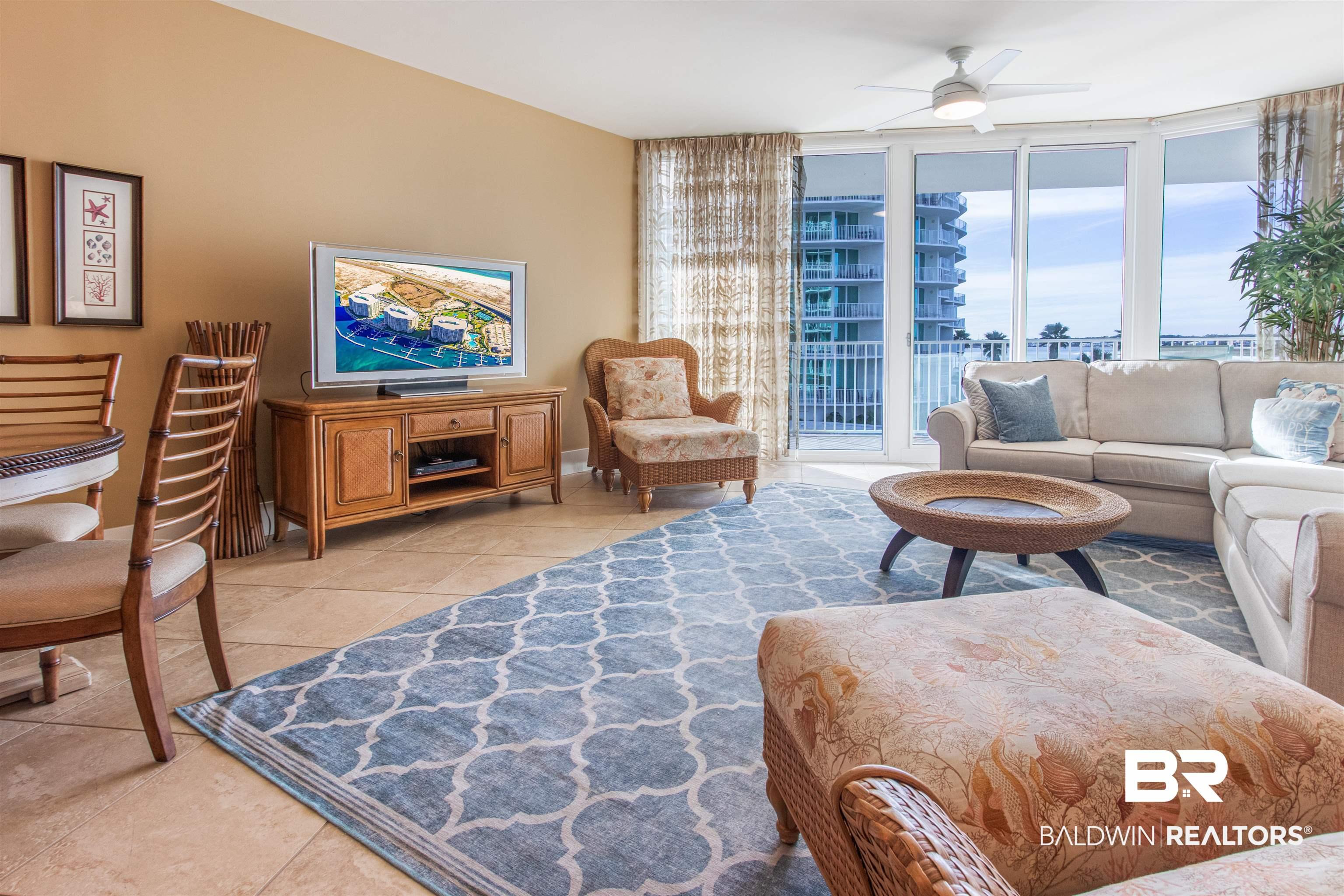 Image 2: Living room featuring a wall of windows, ceiling fan, and light tile patterned floors