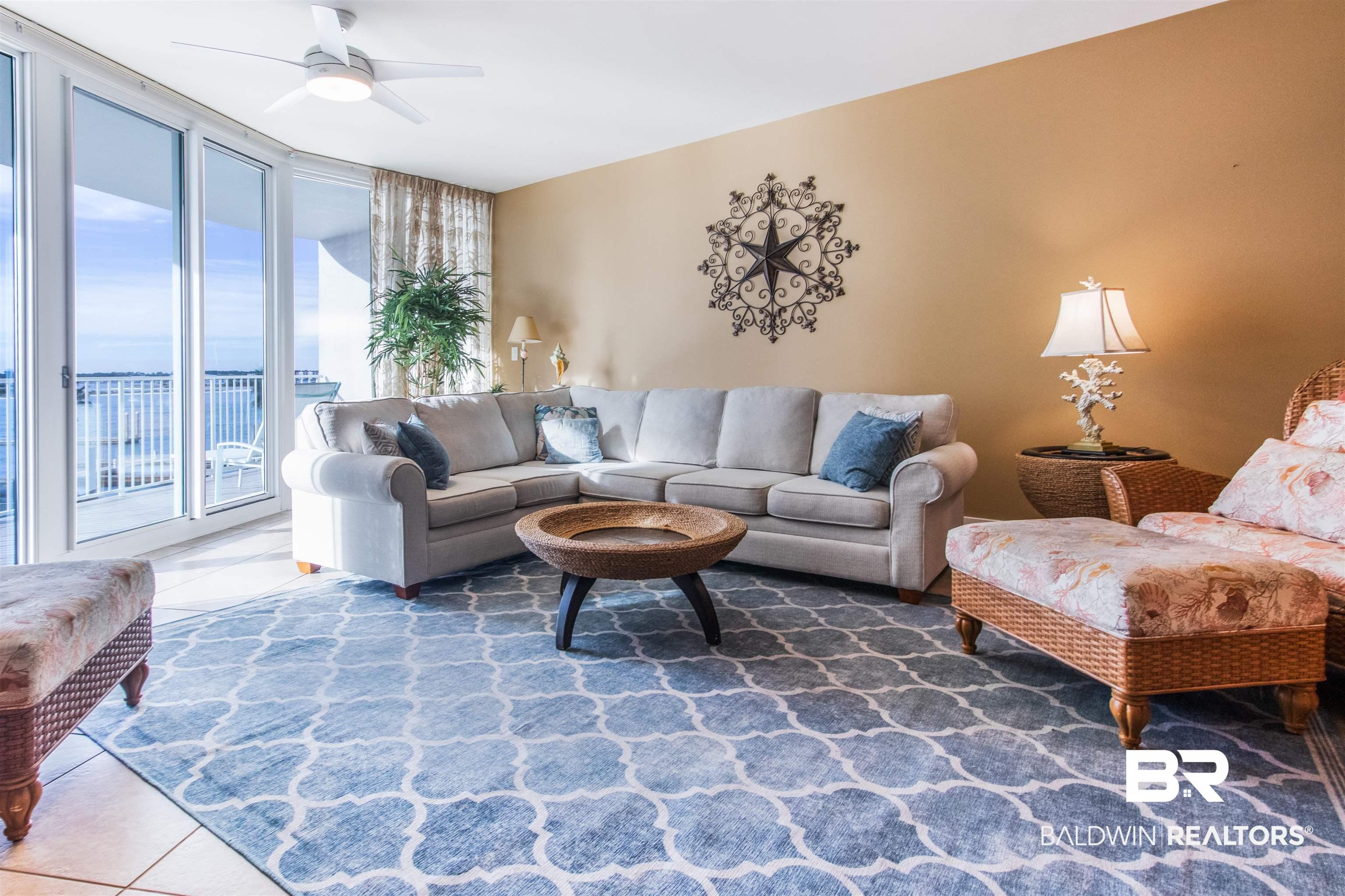 Image 4: Living area featuring tile patterned flooring, a wall of windows, and a ceiling fan