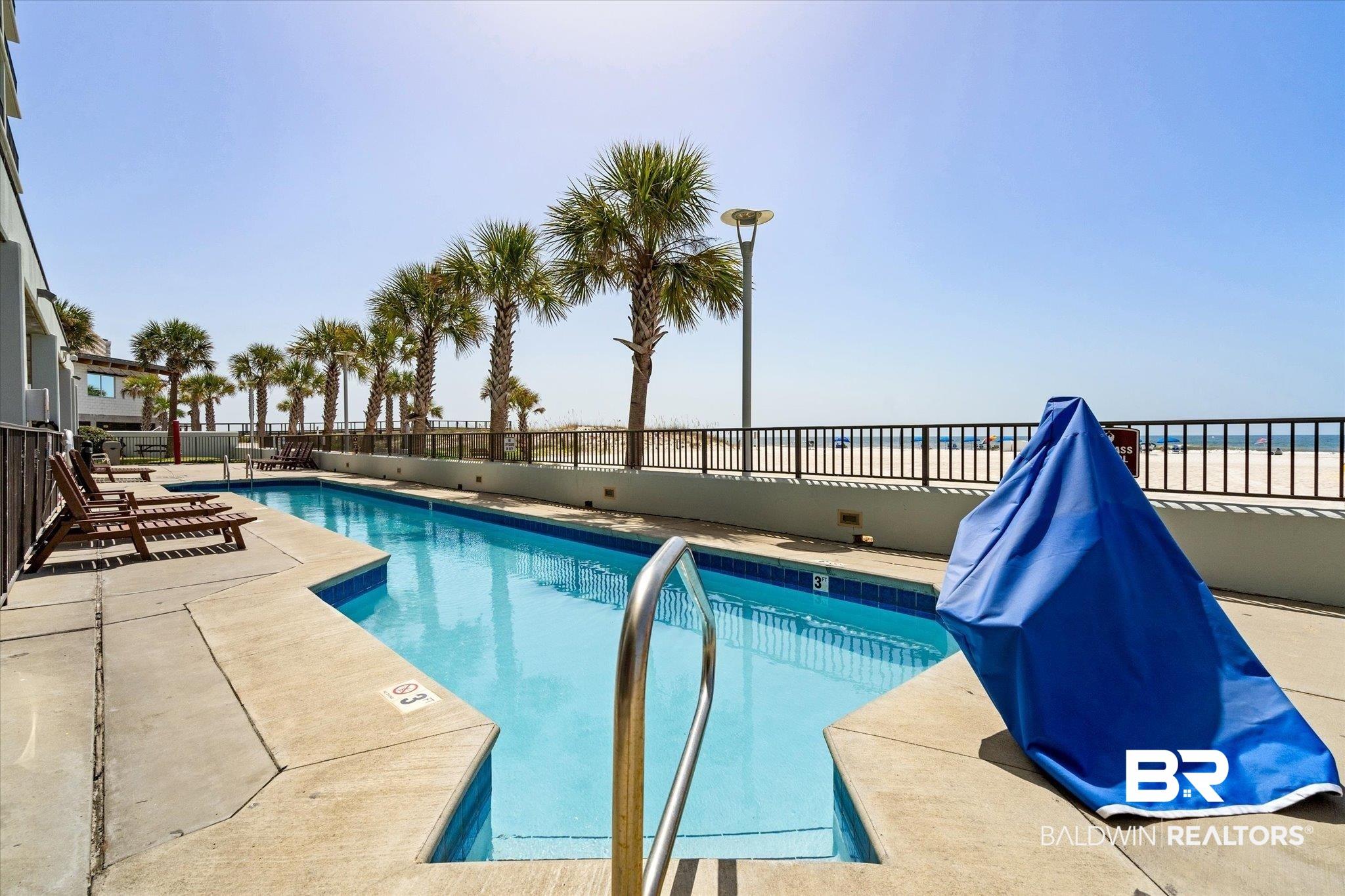 Image 3: Community pool with a patio area