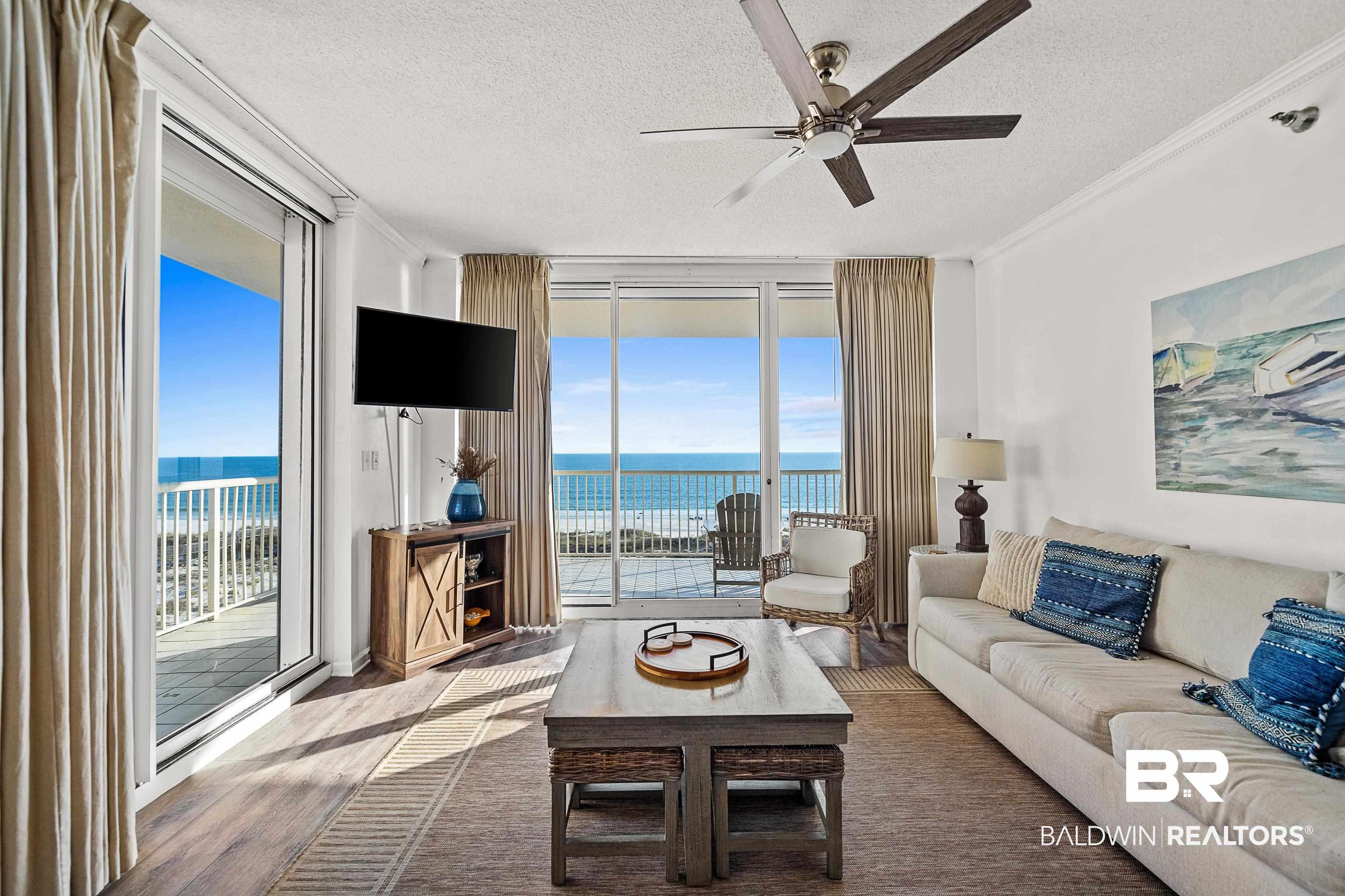 Image 3: Living room featuring a wall of windows, a textured ceiling, wood finished floors, a ceiling fan, and crown molding