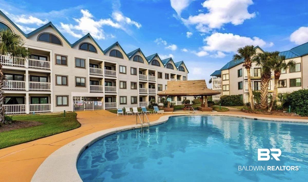 Image 3: Outdoor swimming pool with integrated steps, surrounded by a concrete deck and manicured lawn