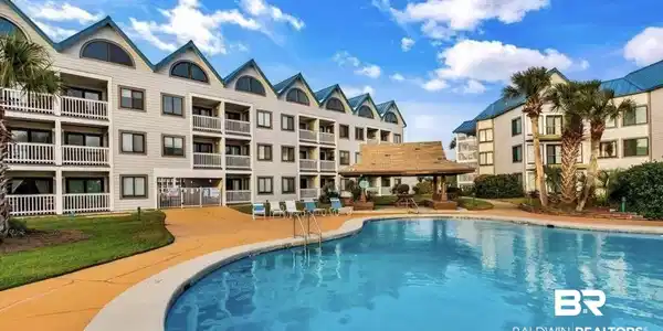 Image 3: Outdoor swimming pool with integrated steps, surrounded by a concrete deck and manicured lawn