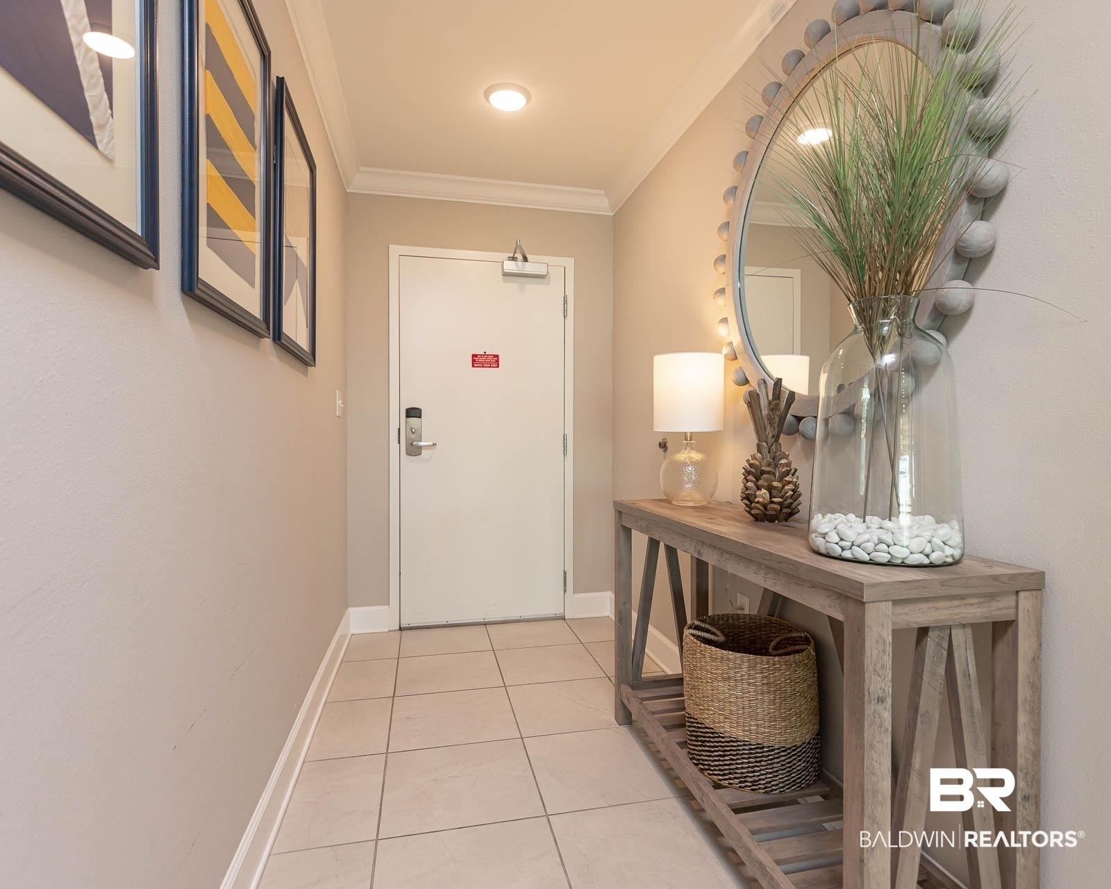 Image 2: Doorway with crown molding and tile patterned floors