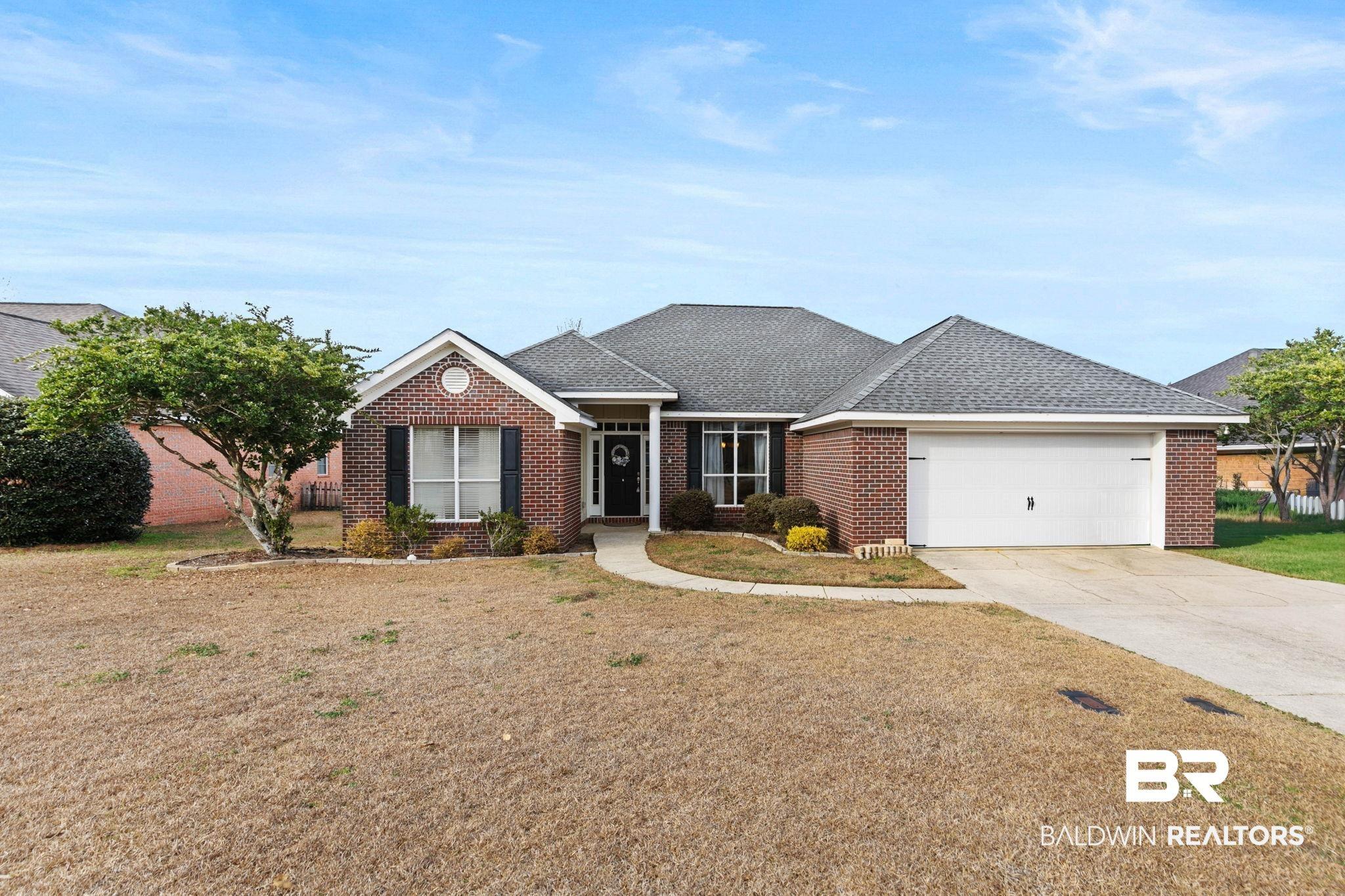Image 1: Ranch-style house with roof with shingles, brick siding, driveway, a garage, and a front yard
