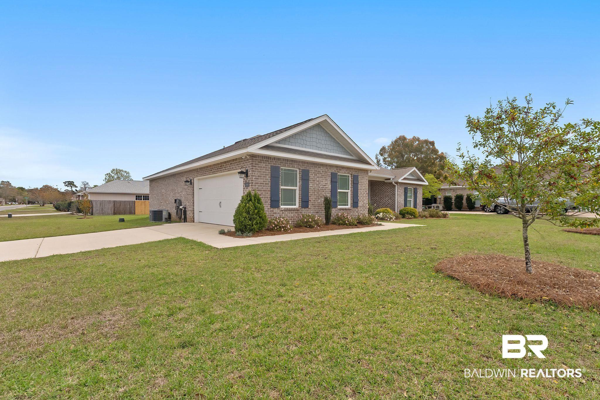 Image 2: Ranch-style house with brick siding, a front lawn, driveway, and a garage