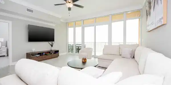 Image 2: Living room with crown molding, floor to ceiling windows, light tile patterned flooring, and a ceiling fan