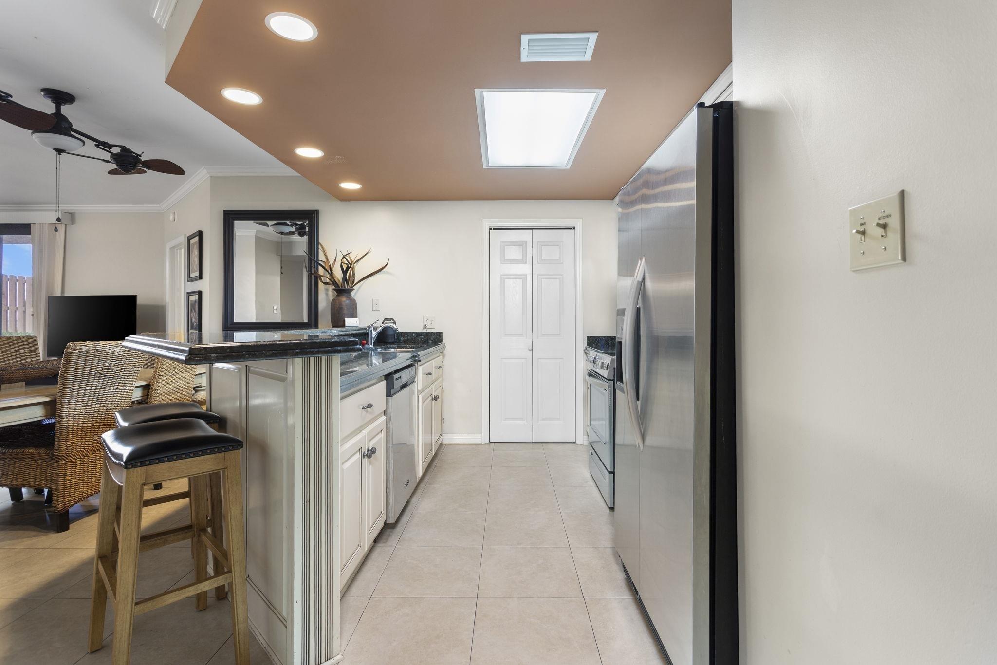 Image 2: Kitchen featuring recessed lighting, a breakfast bar, a peninsula, stainless steel appliances, and ornamental molding