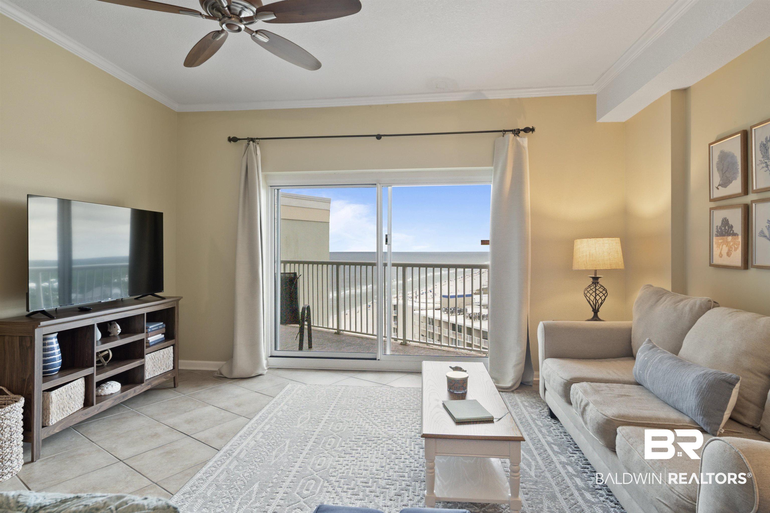 Image 2: Living area featuring ornamental molding, tile patterned flooring, and a ceiling fan