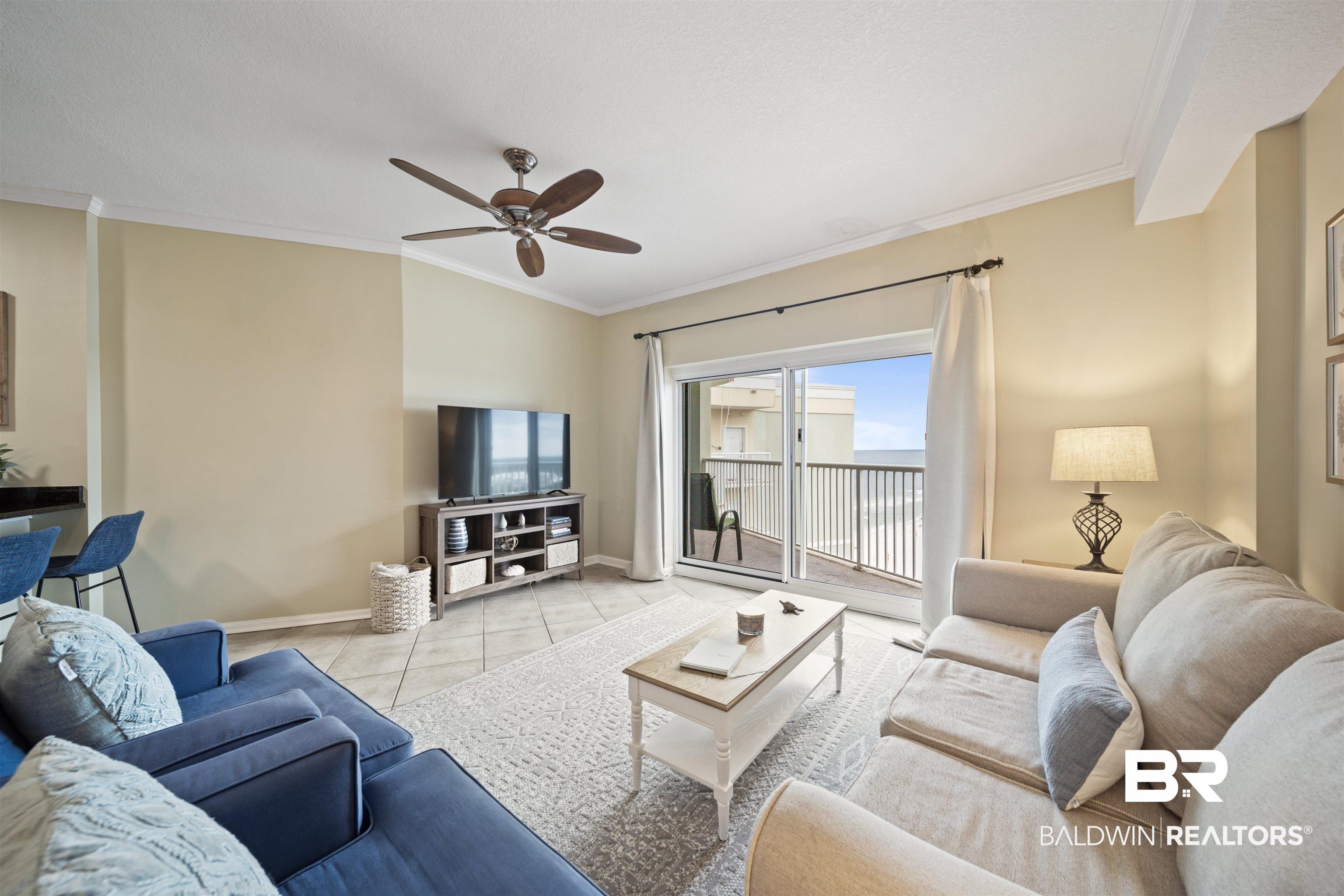 Image 3: Living room featuring crown molding, tile patterned floors, and a ceiling fan