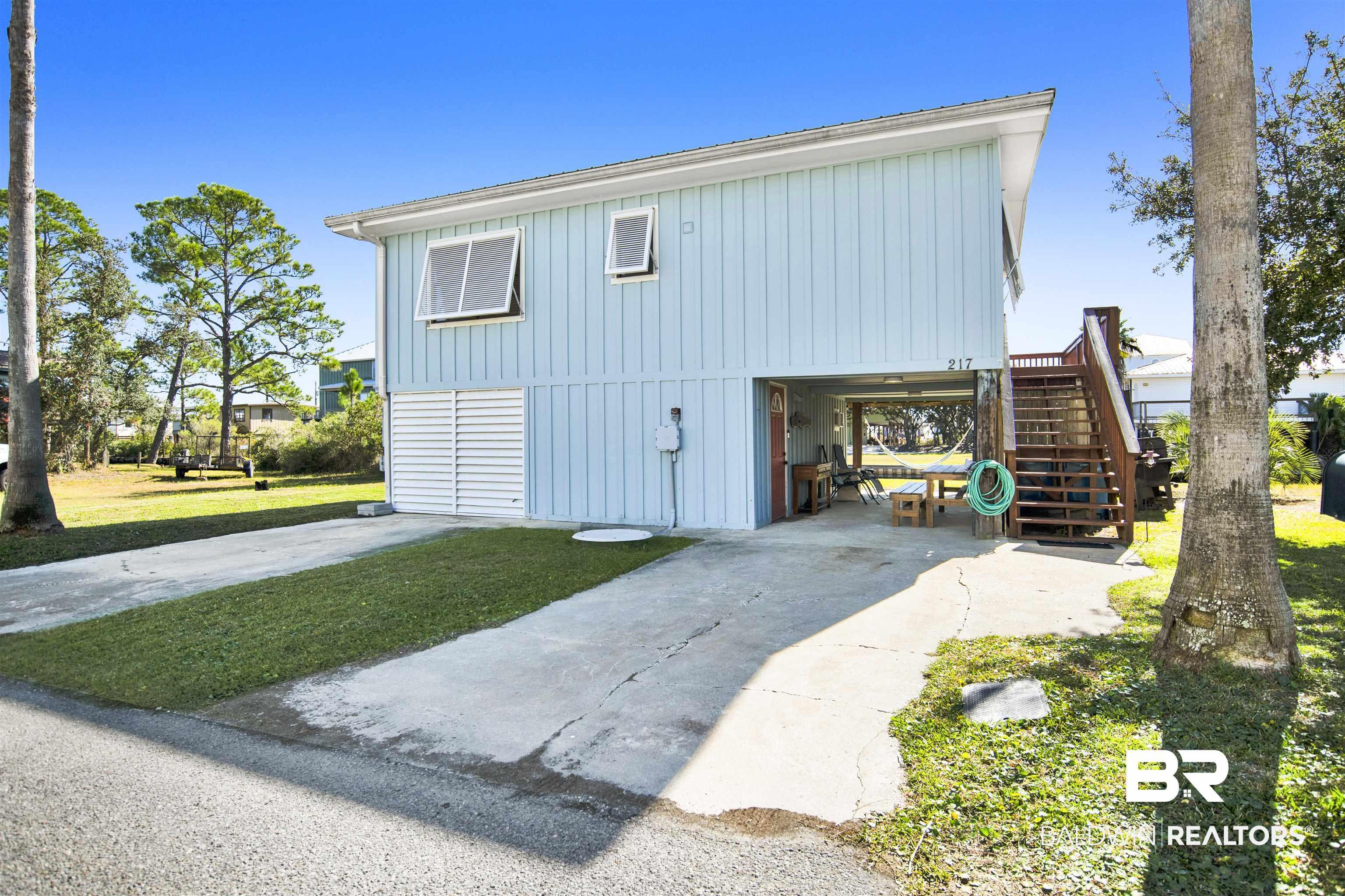 Image 3: View of side of home with stairs, board and batten siding, and a yard