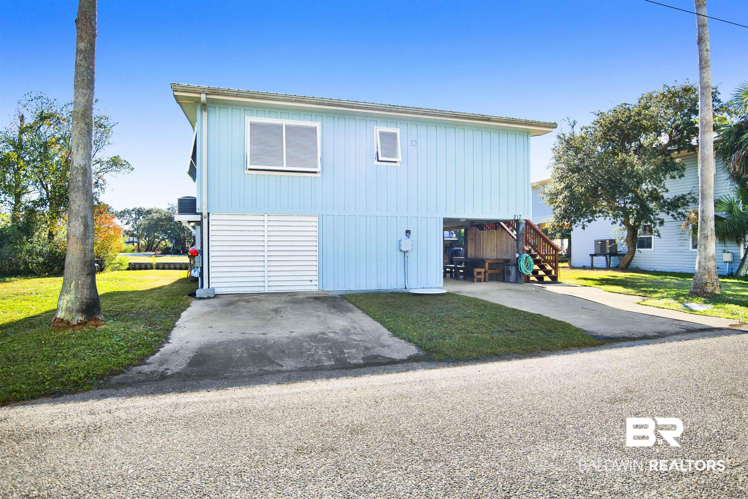 Image 4: View of front of home with a front lawn, stairway, and concrete driveway