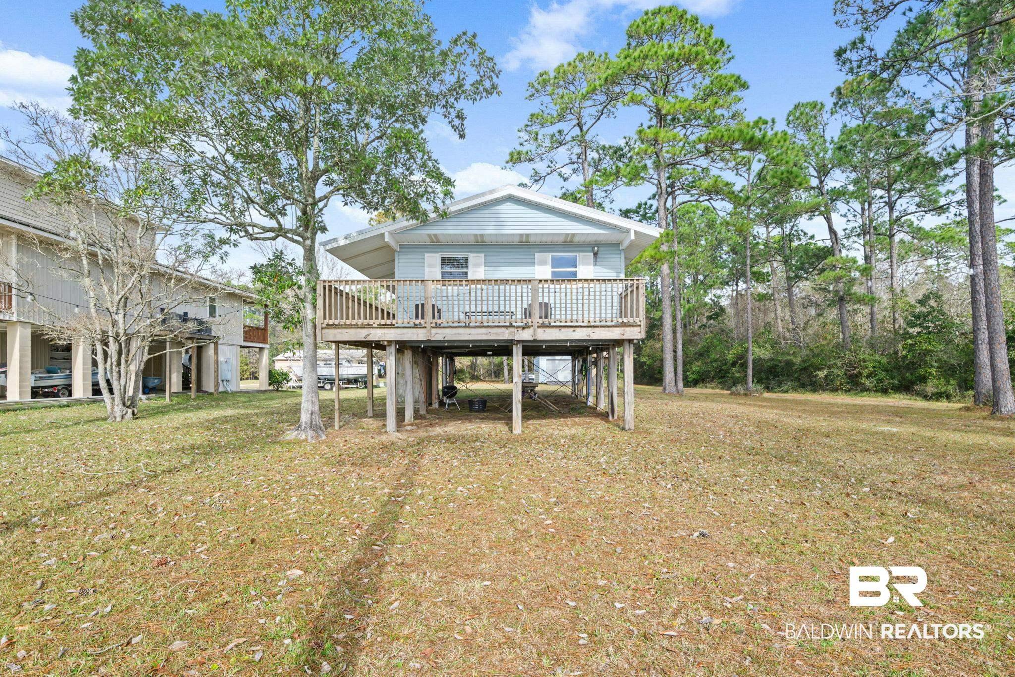 Image 1: Back of property featuring a deck, a yard, and a carport