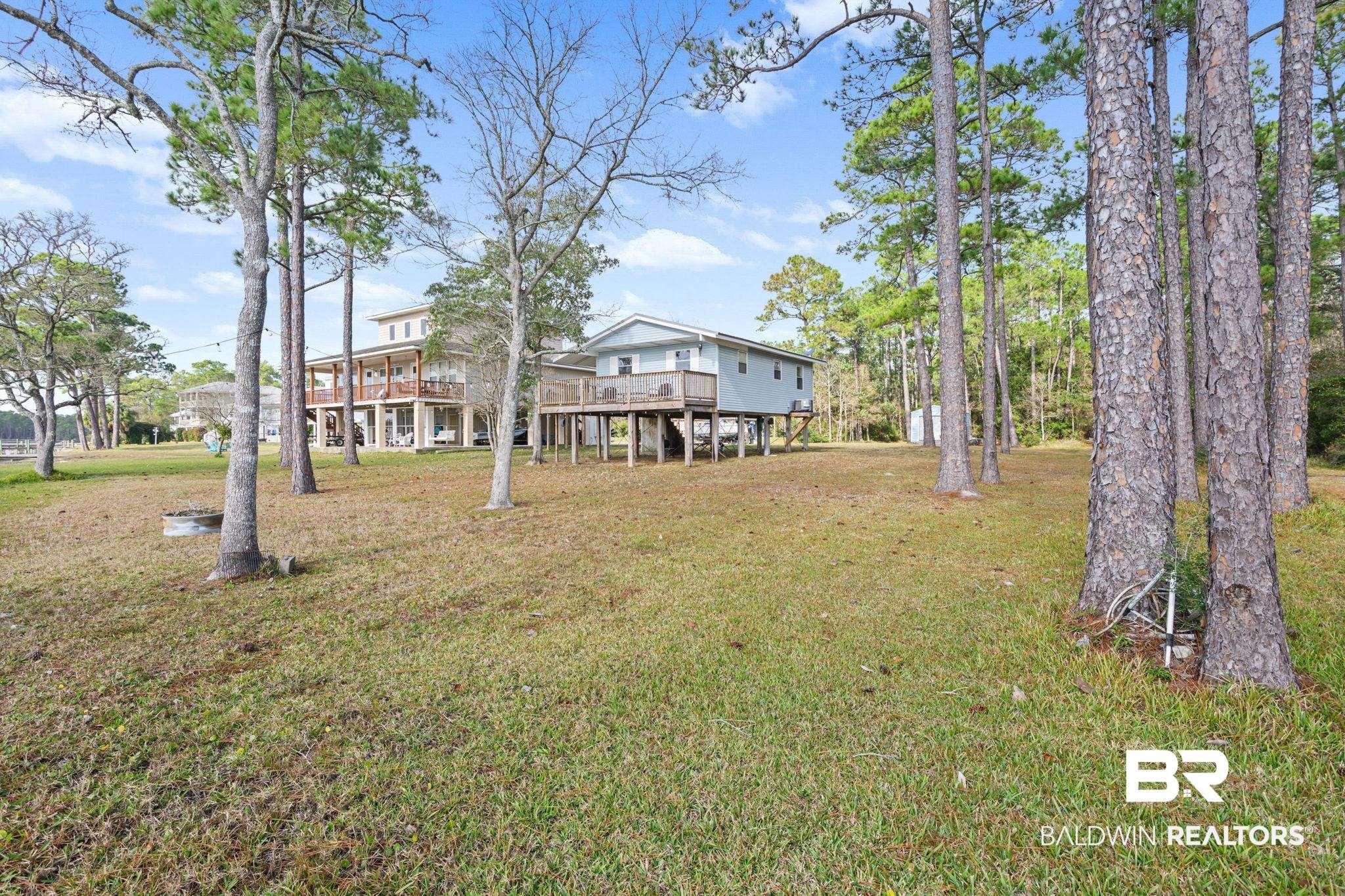 Image 3: View of grassy yard featuring a wooden deck