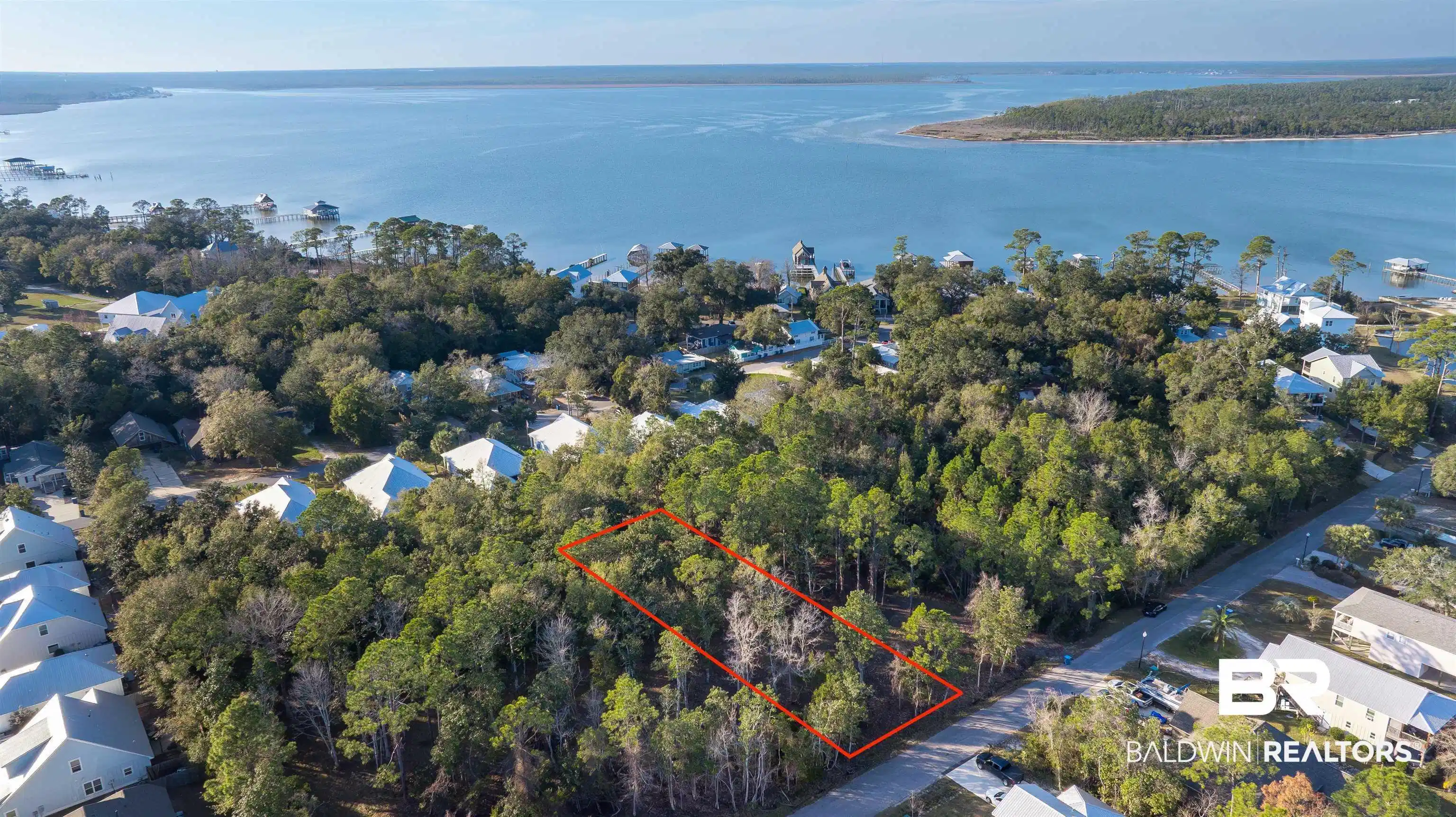 Image 1: Aerial view of property and surrounding area with property parcel outlined and nearby suburban area