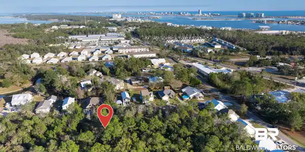 Image 3: Aerial overview of property's location with a large body of water and nearby suburban area
