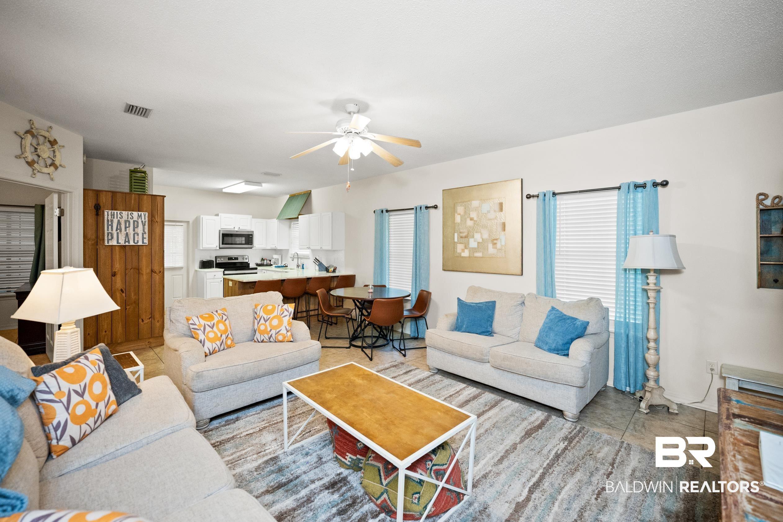Image 3: Living area with light tile patterned flooring and ceiling fan