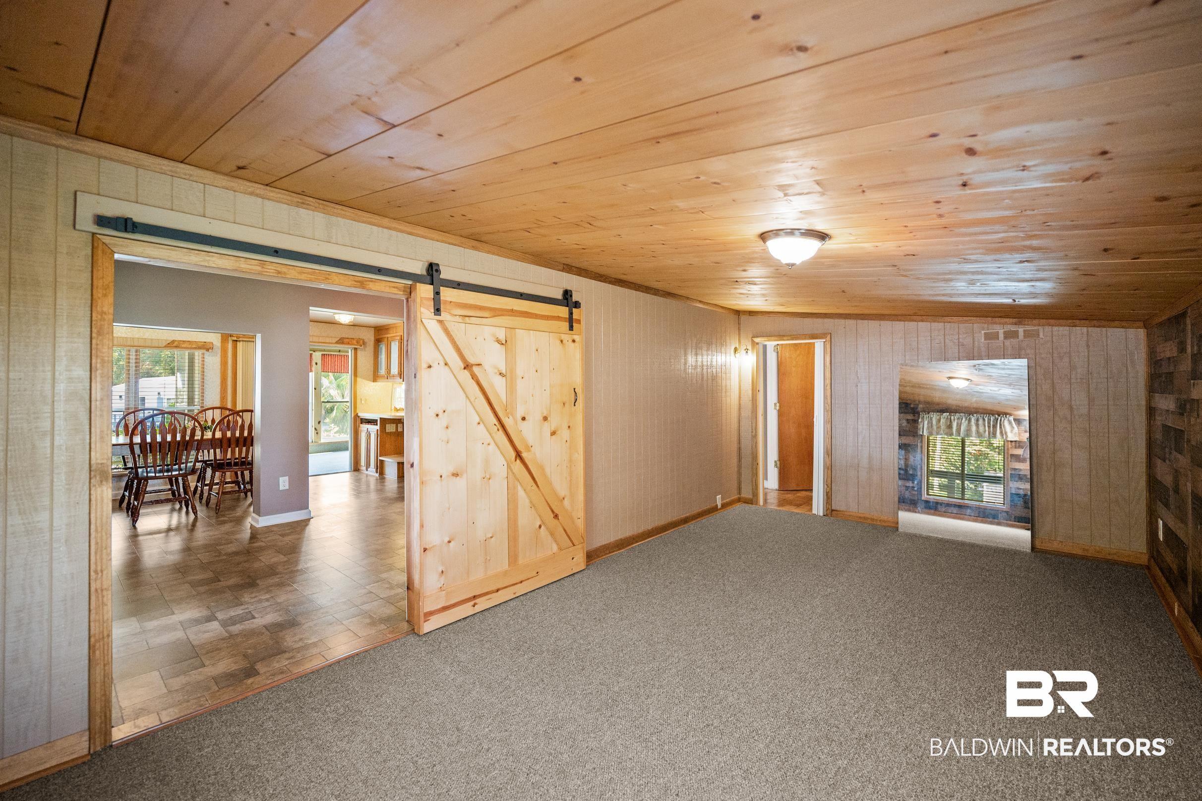 Image 4: Bedroom featuring a barn door, wood ceiling, and carpet floors