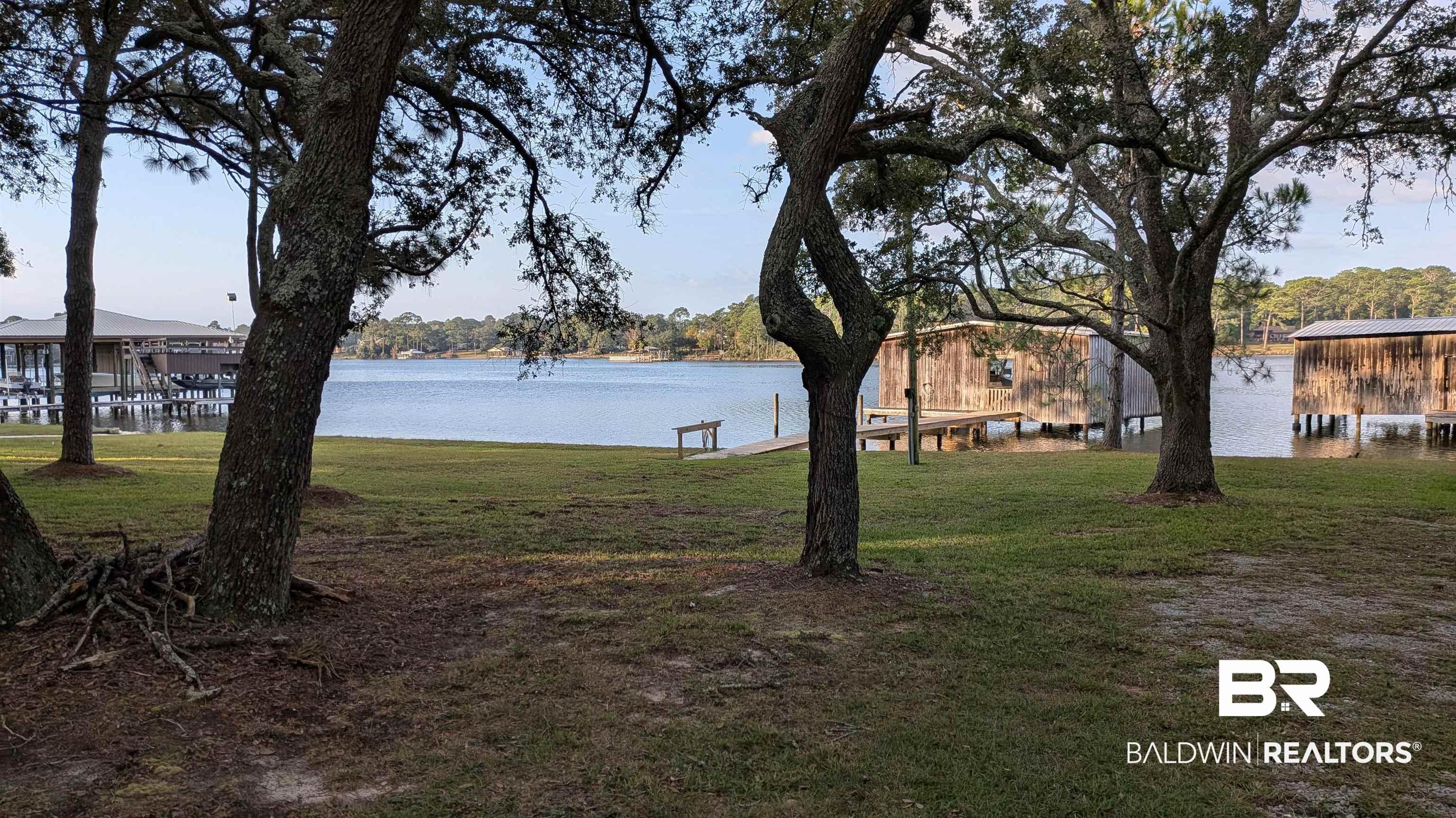 Image 2: View of green lawn with a dock and a water view