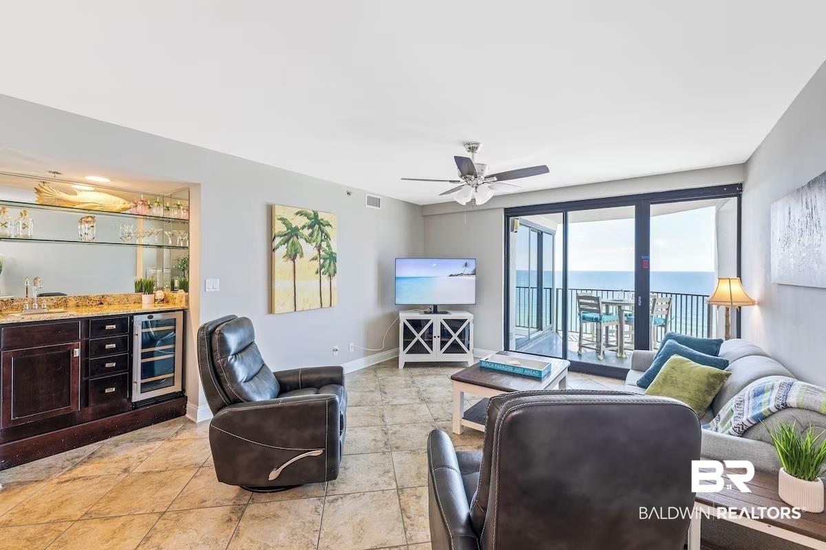 Image 2: Living room with beverage cooler, bar, and ceiling fan
