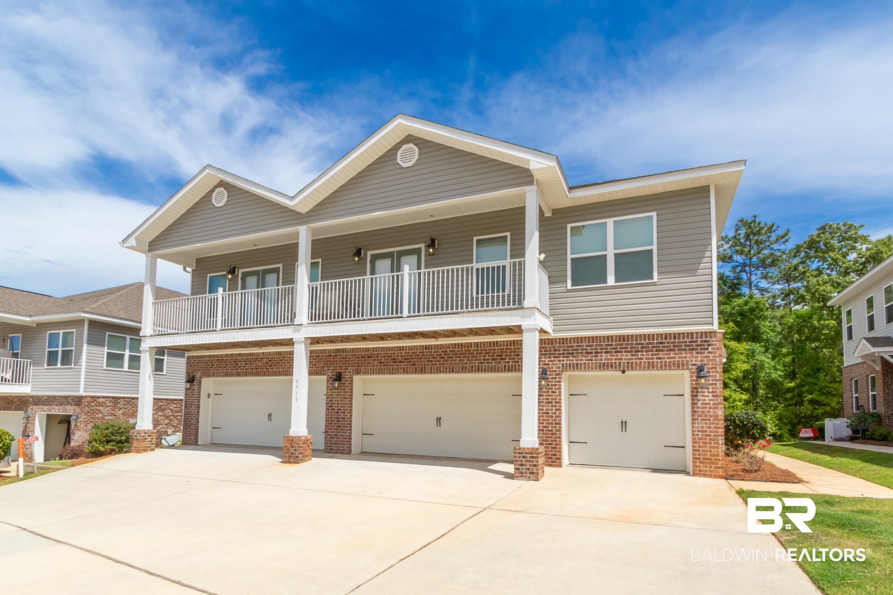 Image 1: View of front facade featuring an attached garage, driveway, brick siding, and covered porch