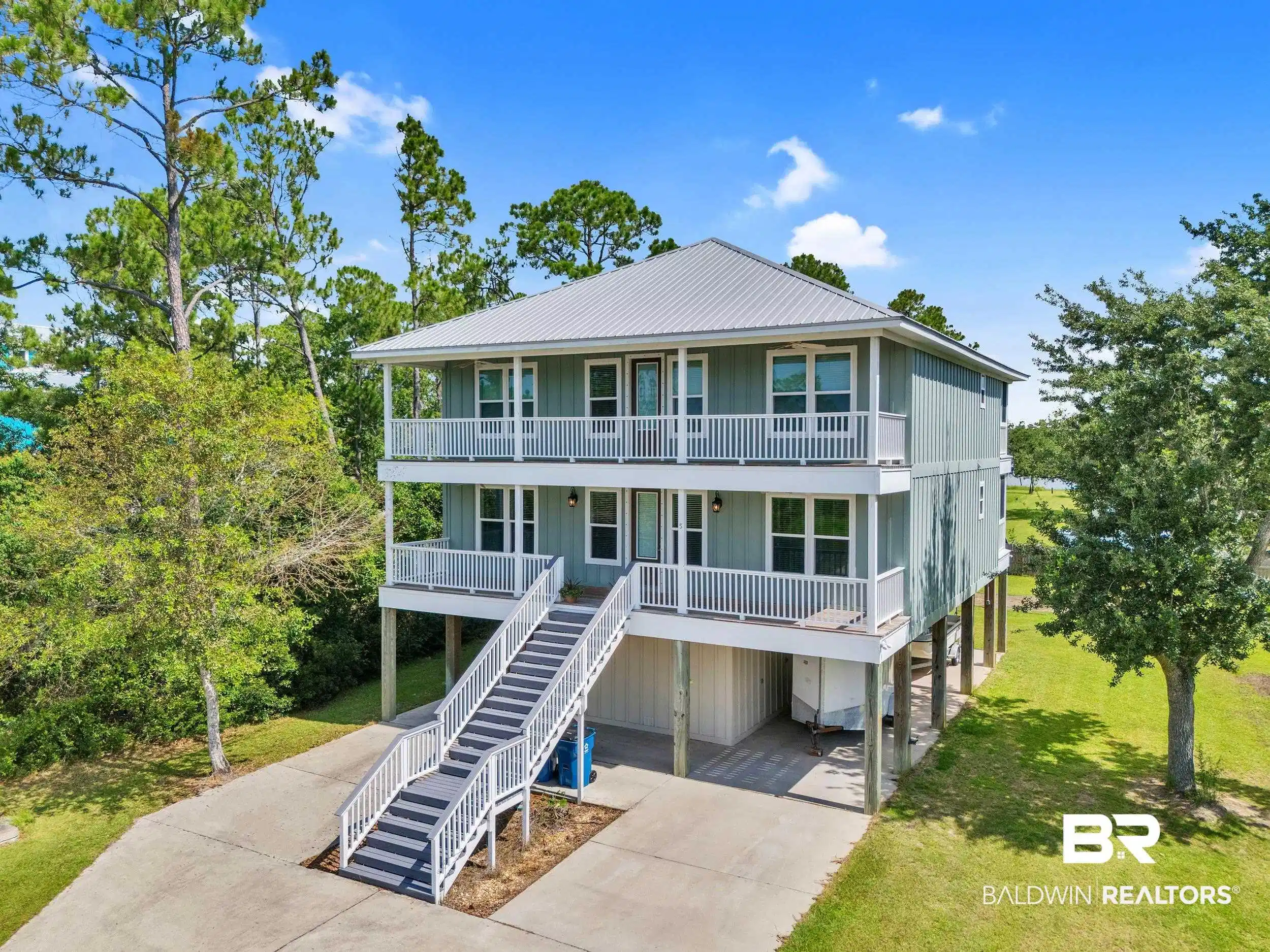 Image 1: View of front of property with a porch, a carport, driveway, a front lawn, and board and batten siding