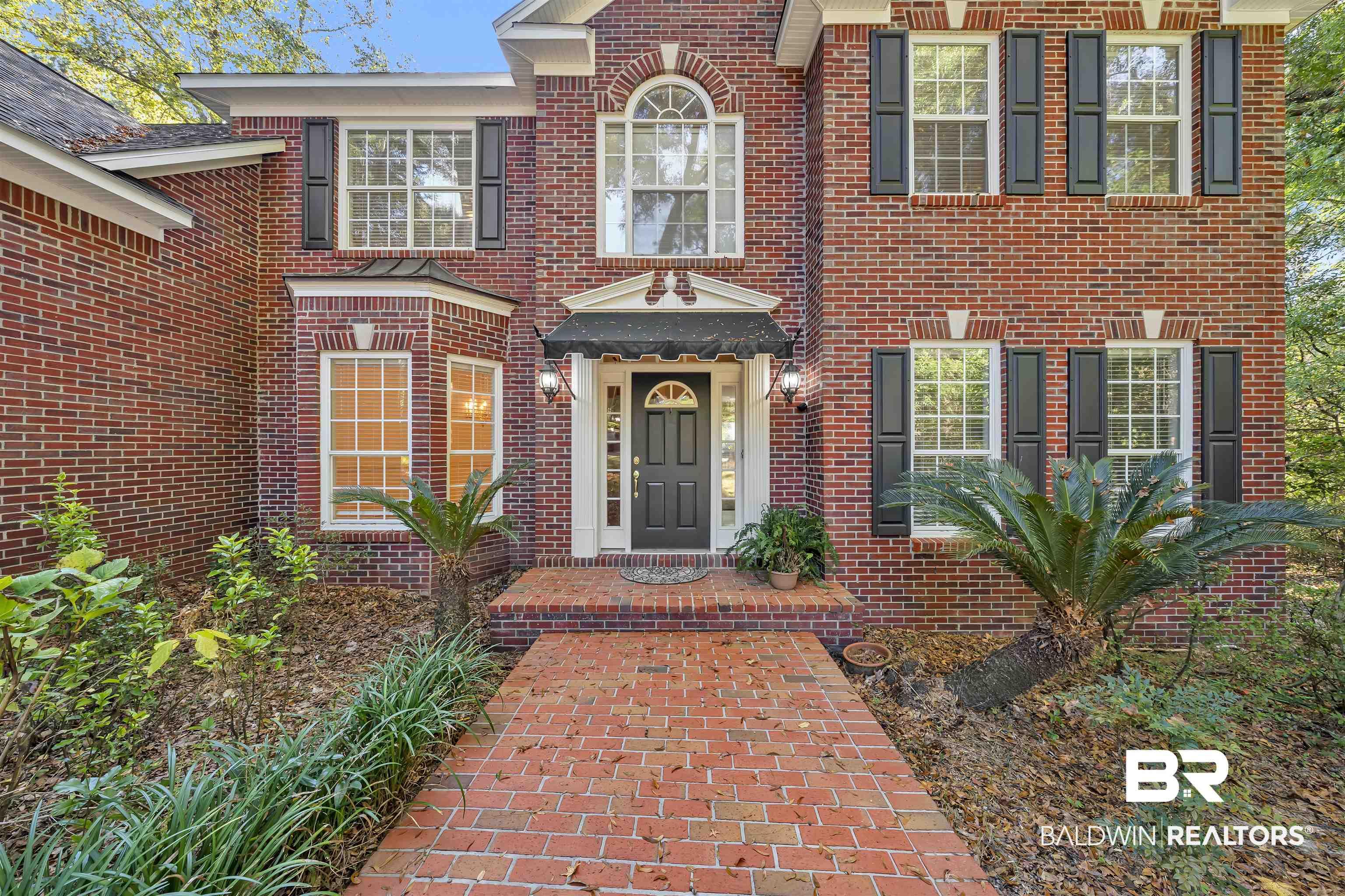 Image 2: Property entrance featuring brick siding