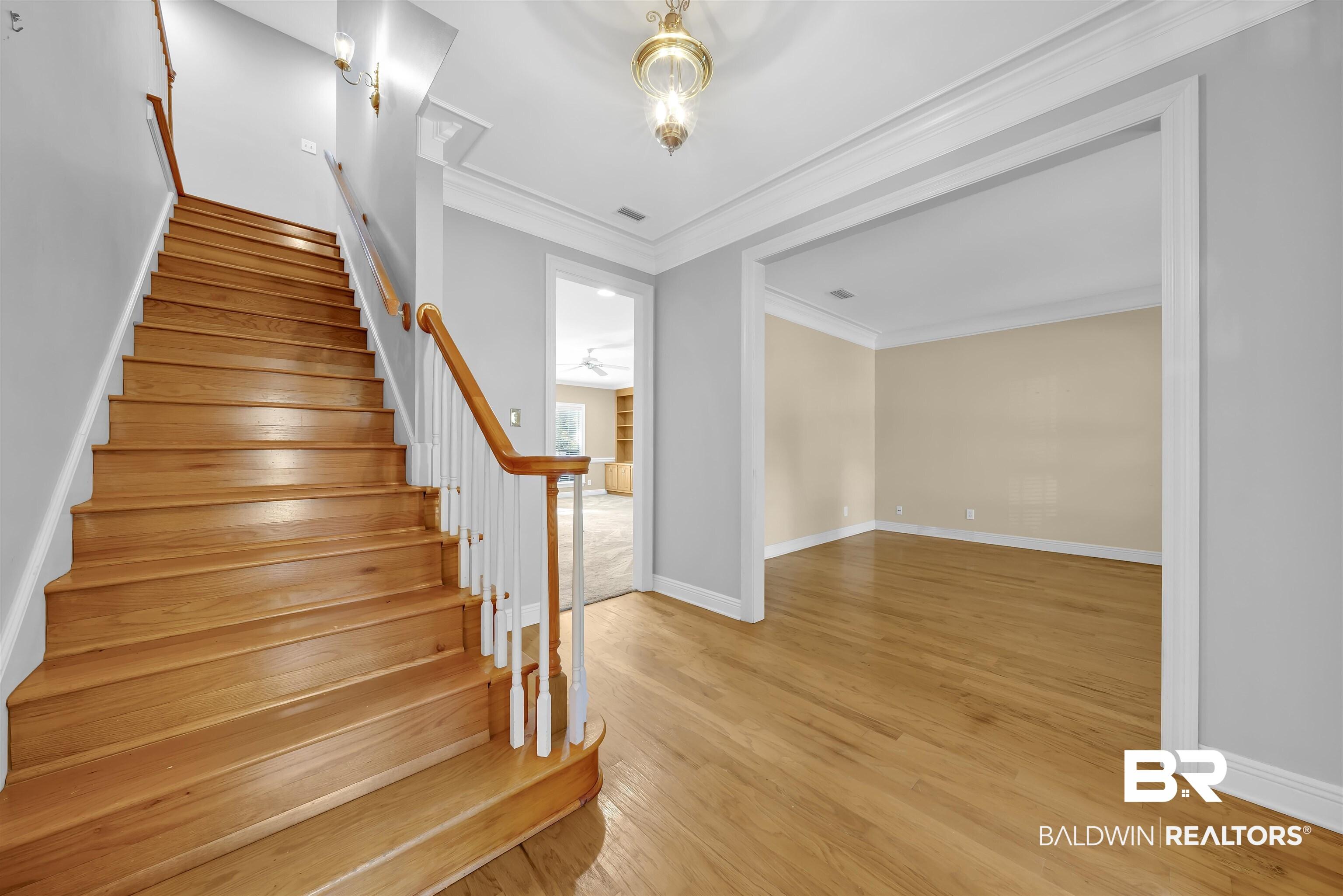 Image 4: Stairs featuring wood-type flooring and ornamental molding