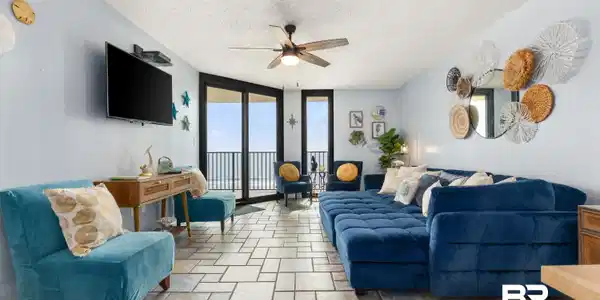 Image 2: Living room featuring floor to ceiling windows, a textured ceiling, ceiling fan, and light stone finish flooring
