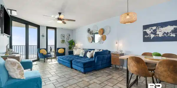 Image 3: Living area with floor to ceiling windows, a textured ceiling, light stone finish floors, and a ceiling fan