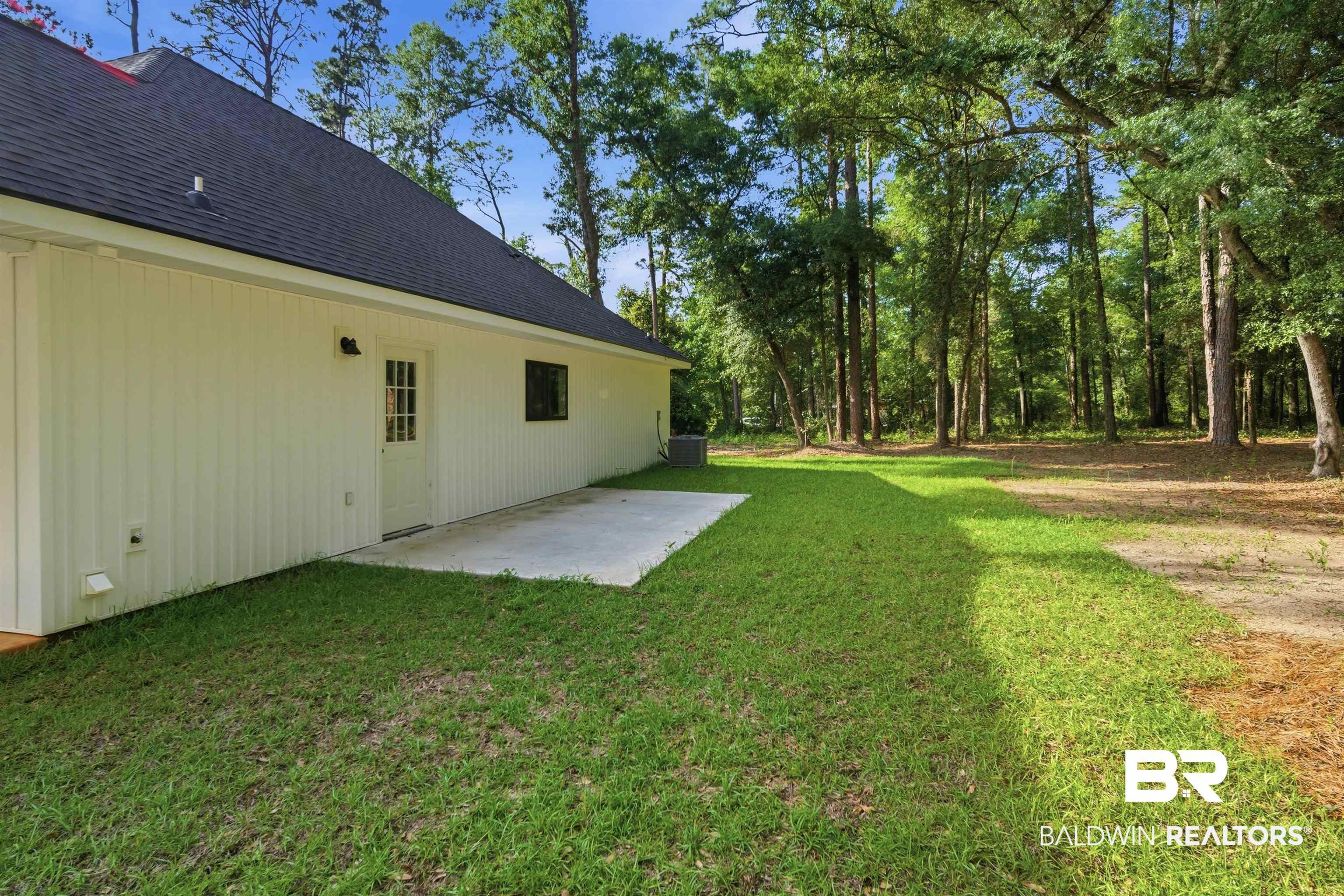 Image 4: Expansive green lawn bordering a concrete patio