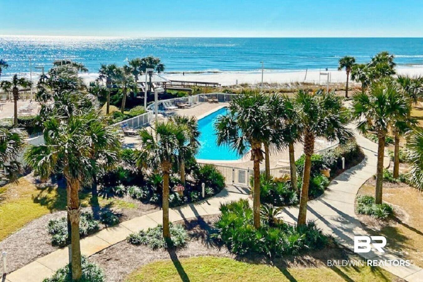 Image 3: Bird's eye view of a pool area and expansive beach