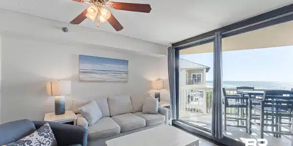 Image 2: Living room with wood finished floors, a water view, a textured ceiling, expansive windows, and ceiling fan