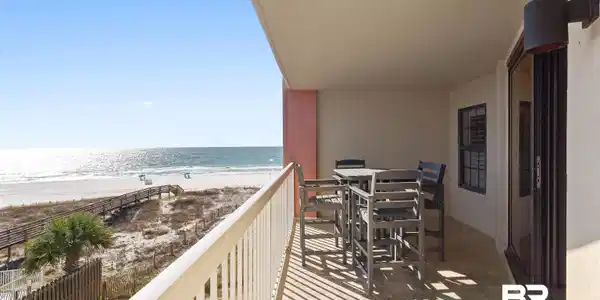 Image 3: Balcony with view of water and beach and outdoor dining area