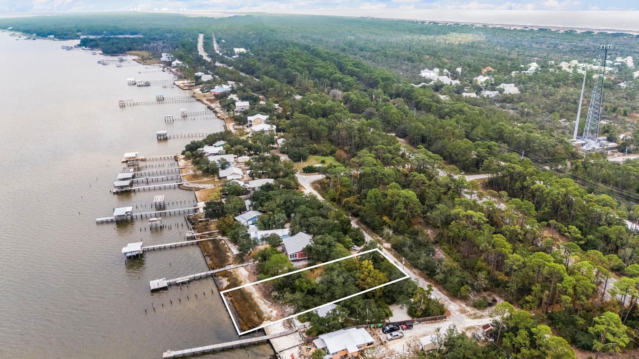 Image 4: Aerial overview of property's location featuring property boundaries highlighted and a large body of water