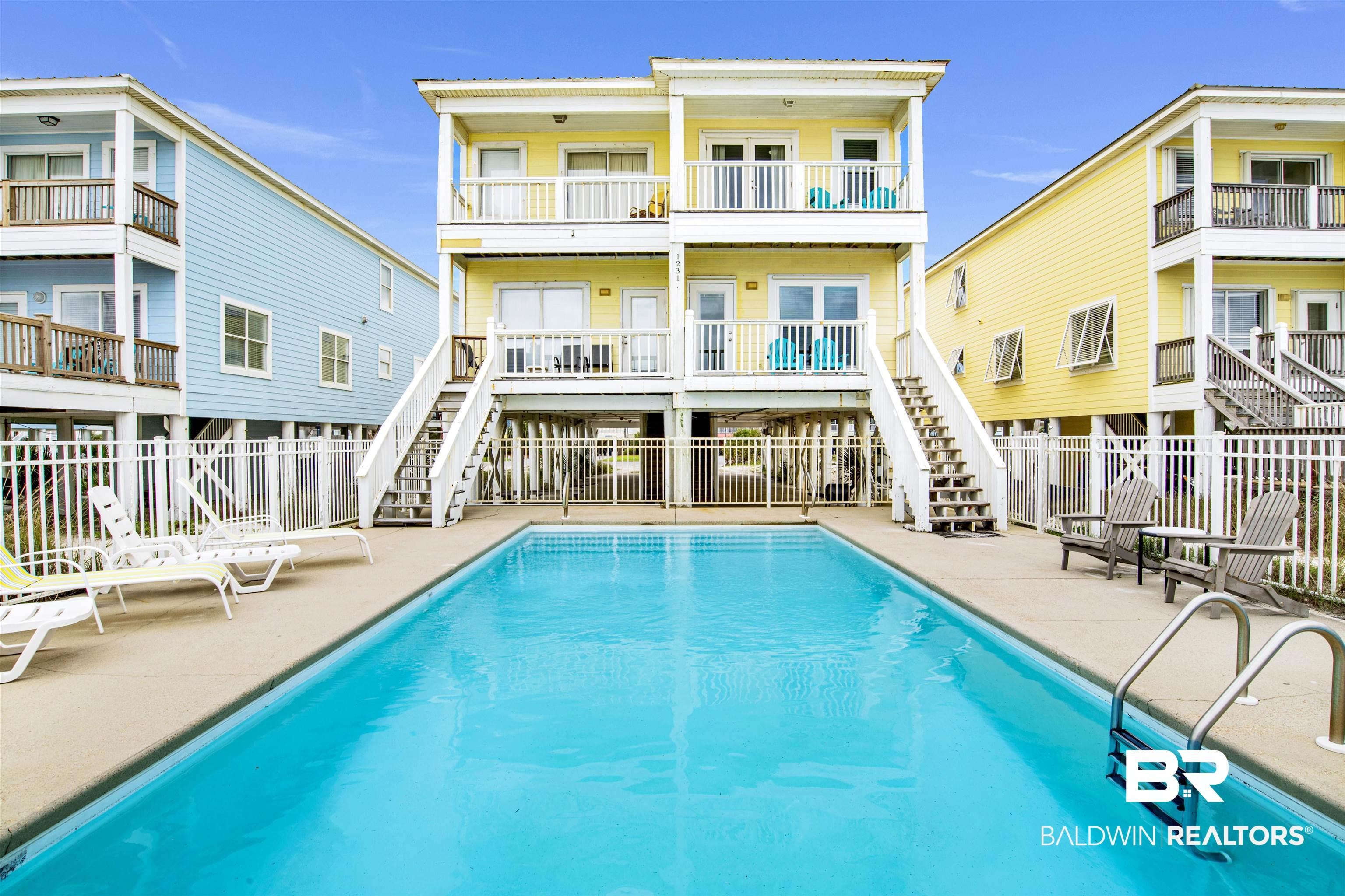 Image 4: Back of house with stairs, a community pool, and a patio