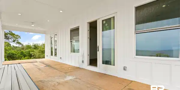 Image 4: Covered outdoor living space featuring white board and batten siding