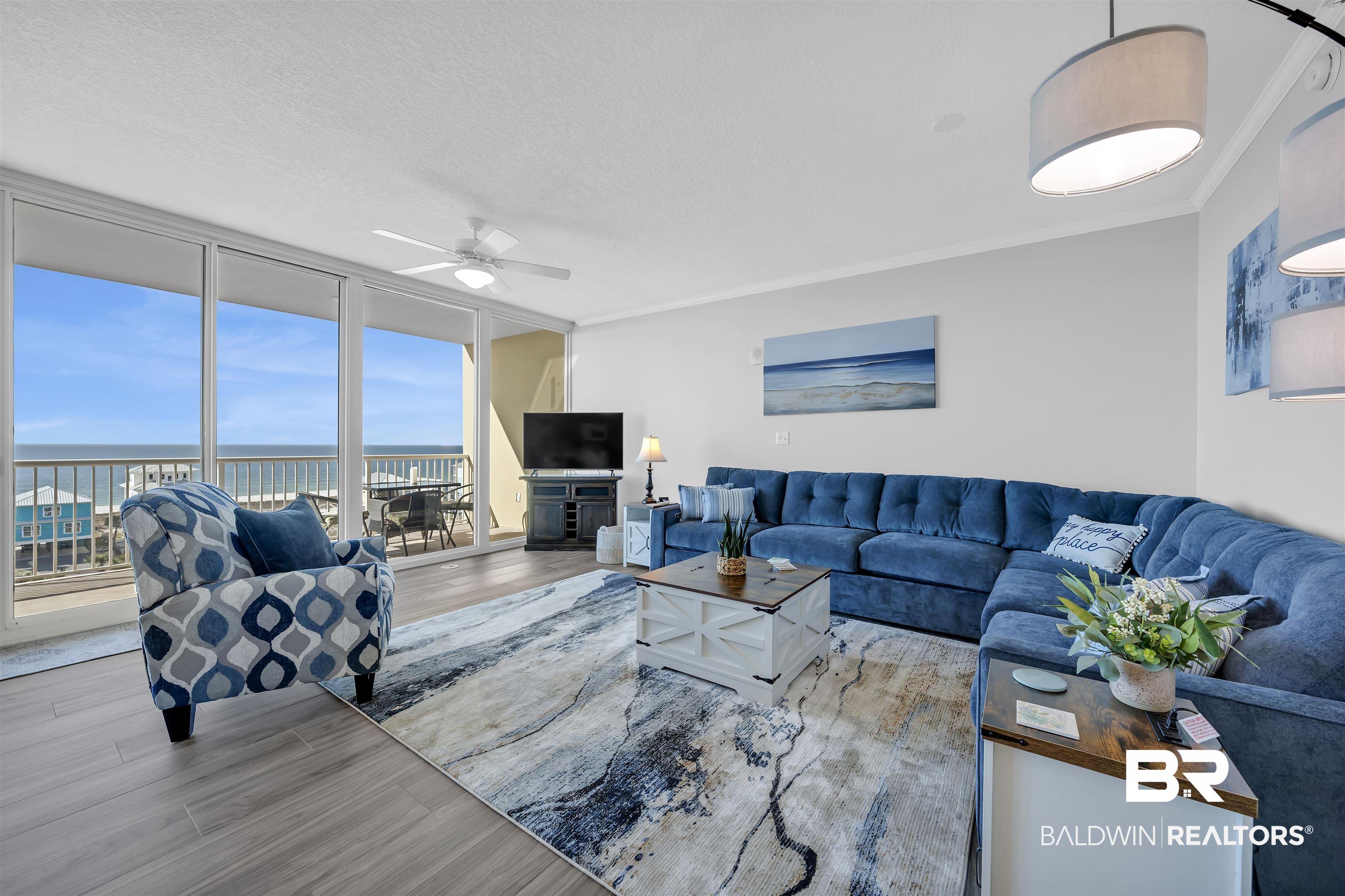 Image 2: Living room featuring expansive windows, wood finished floors, ceiling fan, ornamental molding, and a textured ceiling