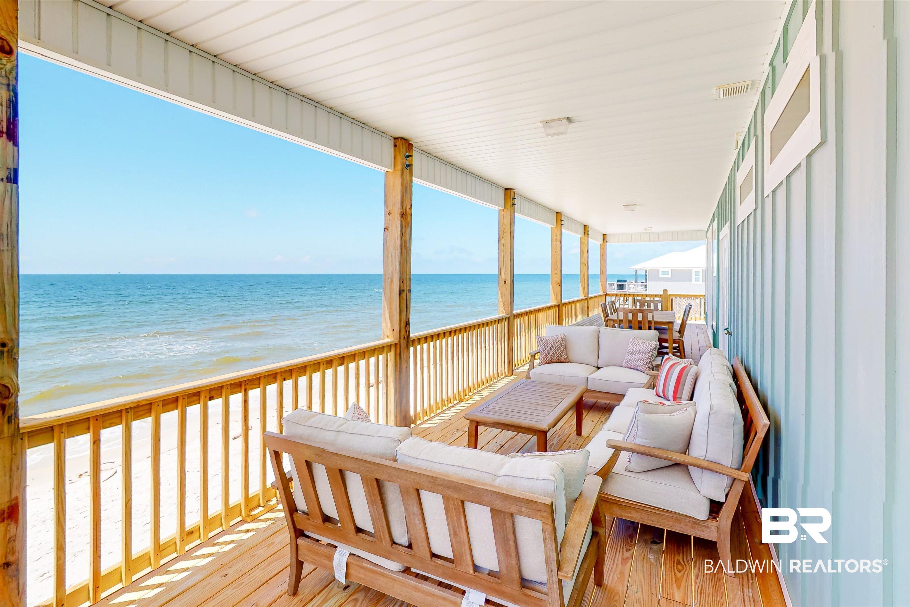 Image 3: Wooden deck featuring outdoor lounge area and view of water and beach