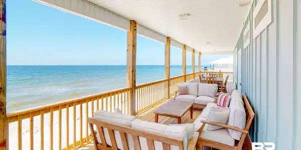 Image 3: Wooden deck featuring outdoor lounge area and view of water and beach