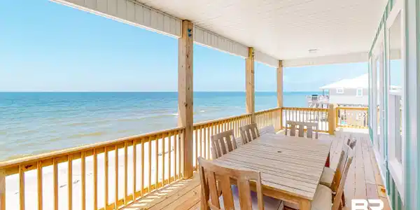 Image 4: Wooden terrace featuring view of water and beach and outdoor dining space