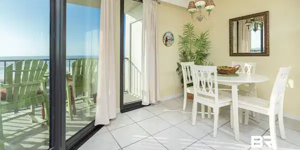 Image 2: Dining space with suspended lighting, light tile patterned floors, and a water view