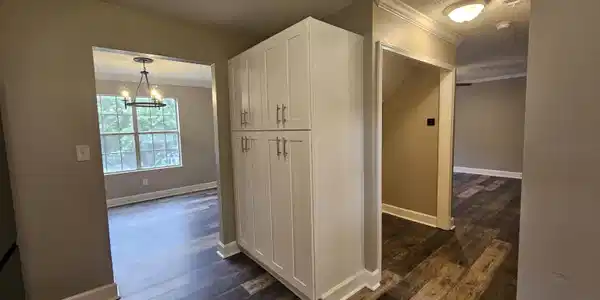 Image 4: Built-in white cabinetry with brushed nickel hardware and wood-finish flooring throughout