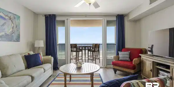 Image 3: Spacious living area featuring light wood-finish flooring, a ceiling fan, and direct balcony access