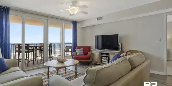 Image 4: Spacious living area featuring expansive glass doors opening to an outdoor balcony
